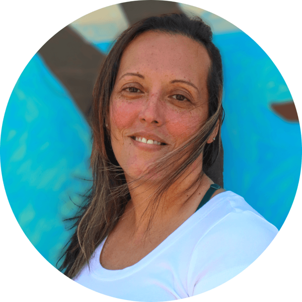 Maridena Rojas smiling in front of a blue mural