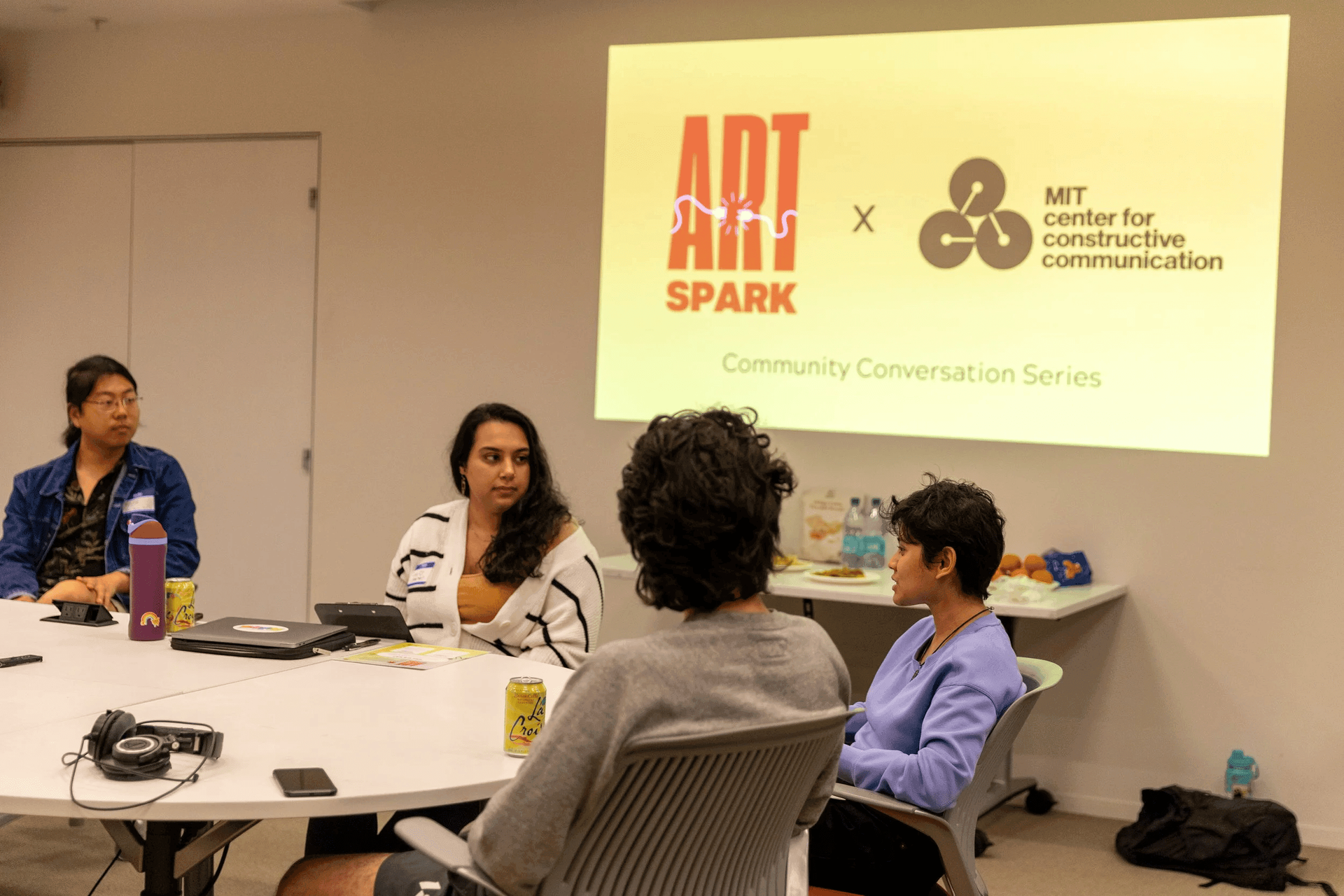 An Art Spark group sits in conversation at an office table